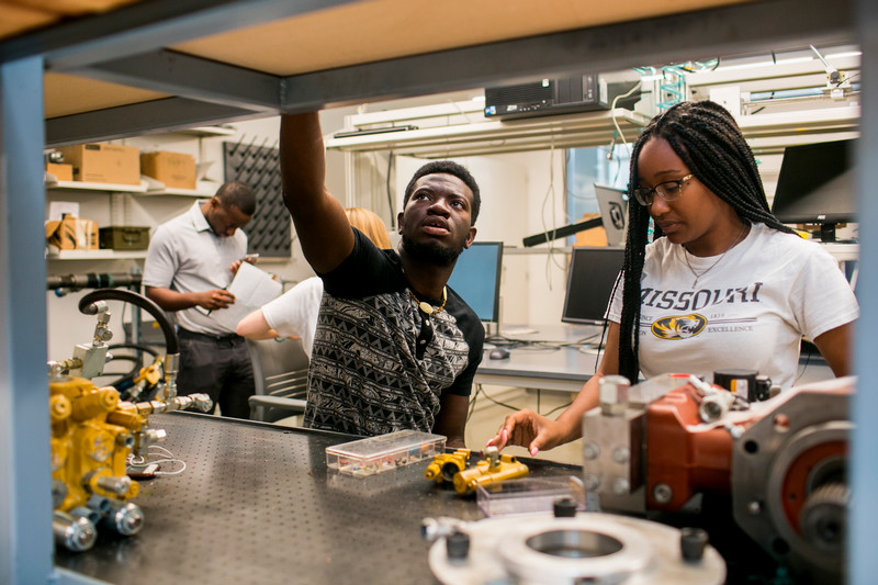 Two African American students working in a small business.